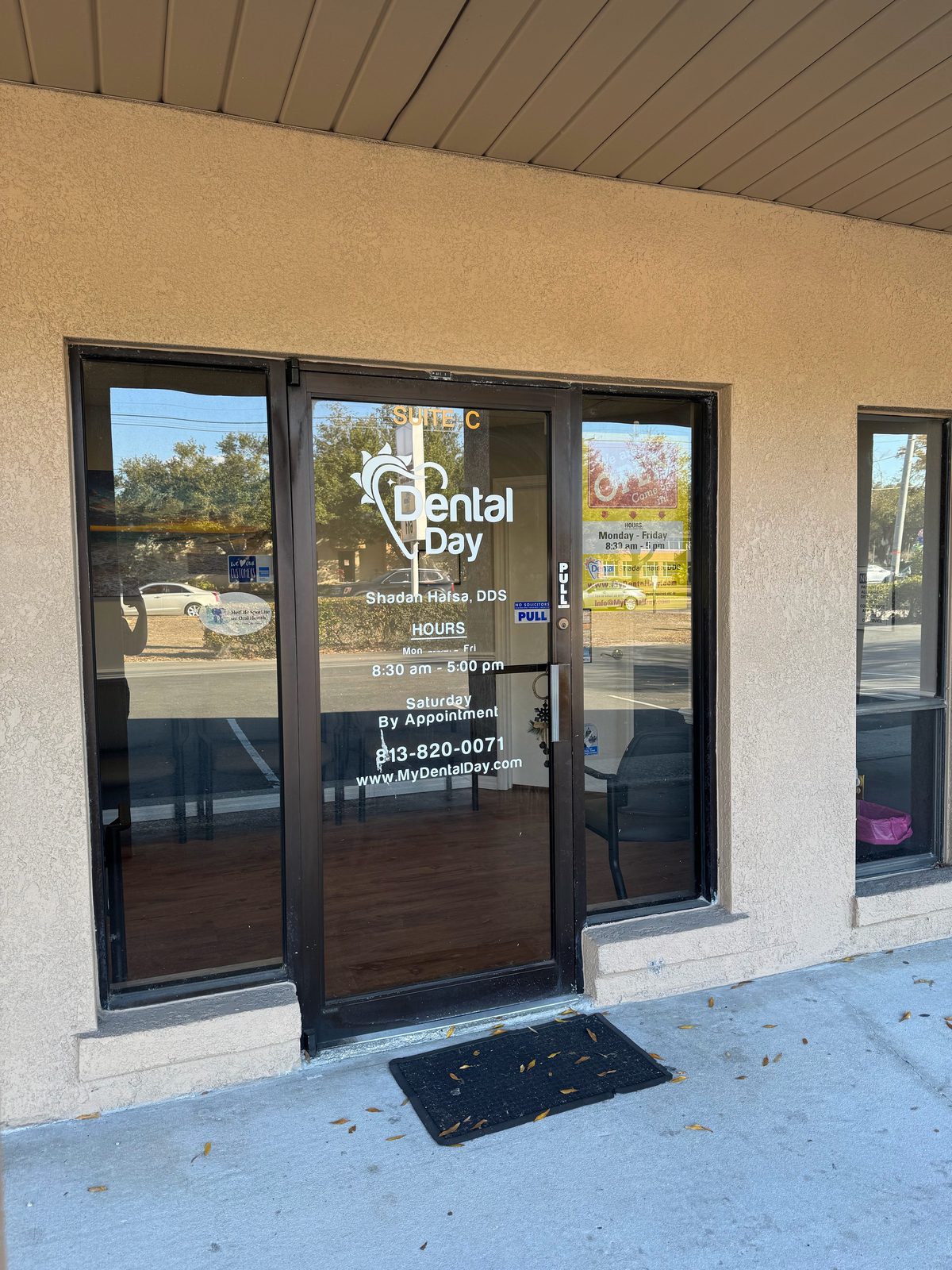Glass front door of Dental Day in Brandon, FL, with the Dental Day logo and Suite C sign